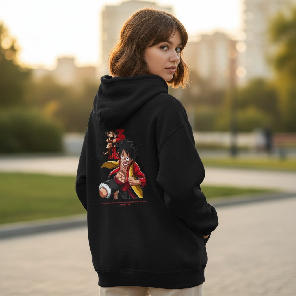 CanvasPrismatique black One Piece Luffy graphic hoodie worn by a woman, showing the dynamic character print on the back.